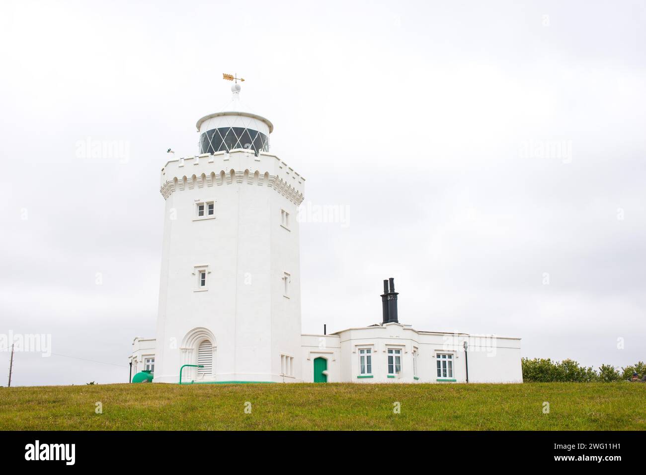 Un phare blanc se dresse devant un ciel couvert sur une prairie verte, phare de South Foreland, falaises blanches de Douvres, Kent, Angleterre, Grande Banque D'Images