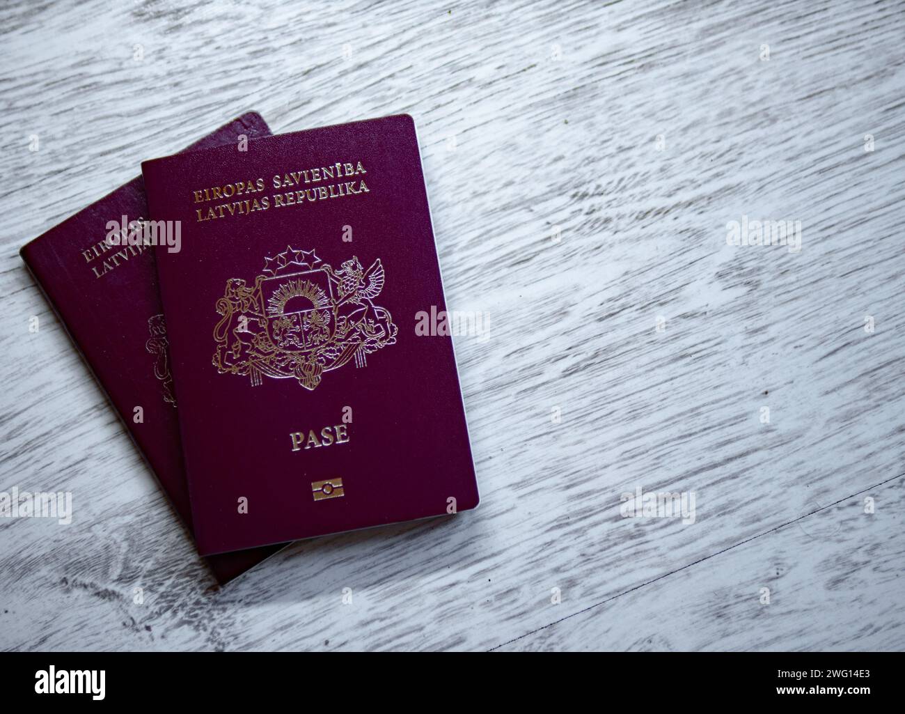 Passeport letton de l'union européenne sur fond blanc en bois Banque D'Images