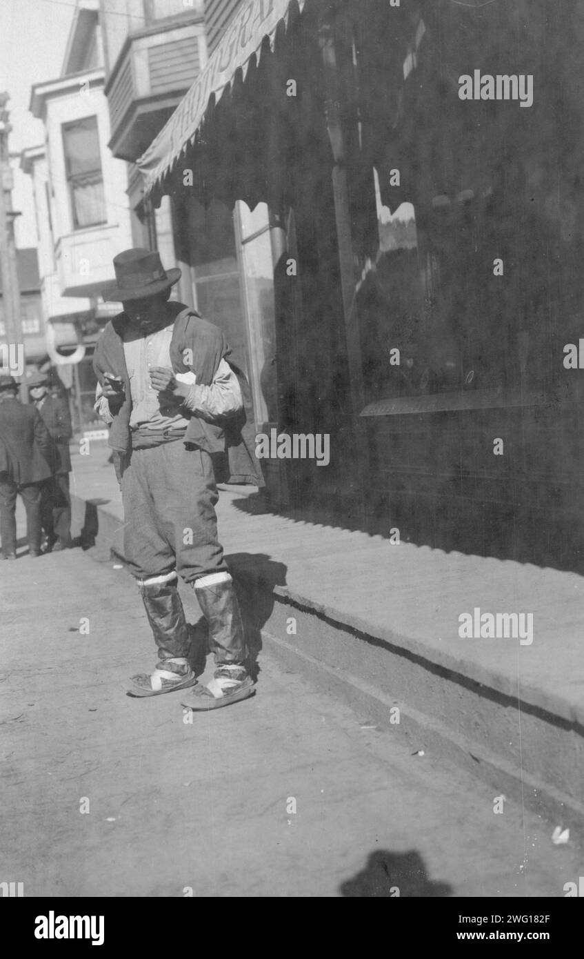 Homme à l'extérieur du magasin, entre c1900 et 1916. Banque D'Images