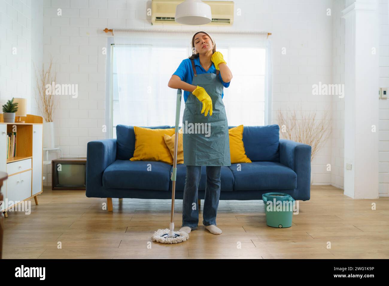 Femme de ménage comme elle nettoie lassablement le sol dans le salon reflète le travail acharné et le dévouement de l'équipe de nettoyage, mettant en évidence l'engagement à Banque D'Images