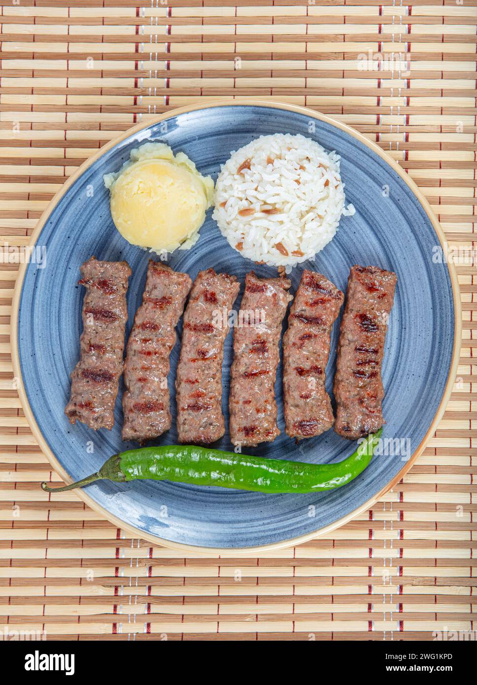 Cuisine turque boulettes de viande inegol. Boulettes de viande grillées sur une assiette. Tekirdag turc ou inegol Kofte avec poivre, riz et purée de pommes de terre, Kofta. Banque D'Images