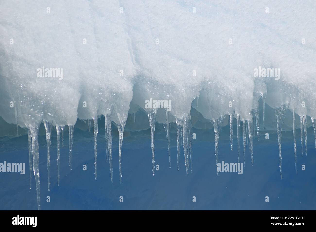 Des glaçons pendent d'un iceberg près de l'île Petermann en Antarctique Banque D'Images