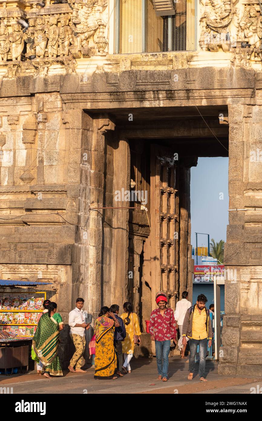 Belur, Karnataka, Inde - janvier 9 2023 : les touristes indiens marchent à travers l'ancienne porte du complexe historique du temple de Chennakeshava. Banque D'Images