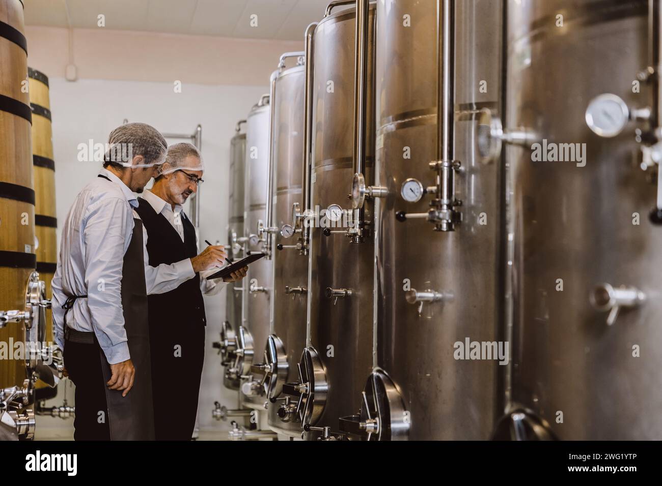Viticulteur professionnel travaillant dans une grande usine de vinification moderne alcool alcool alcool industrie du contrôle de la qualité et de la fermentation surveillent la couleur vintage à Banque D'Images