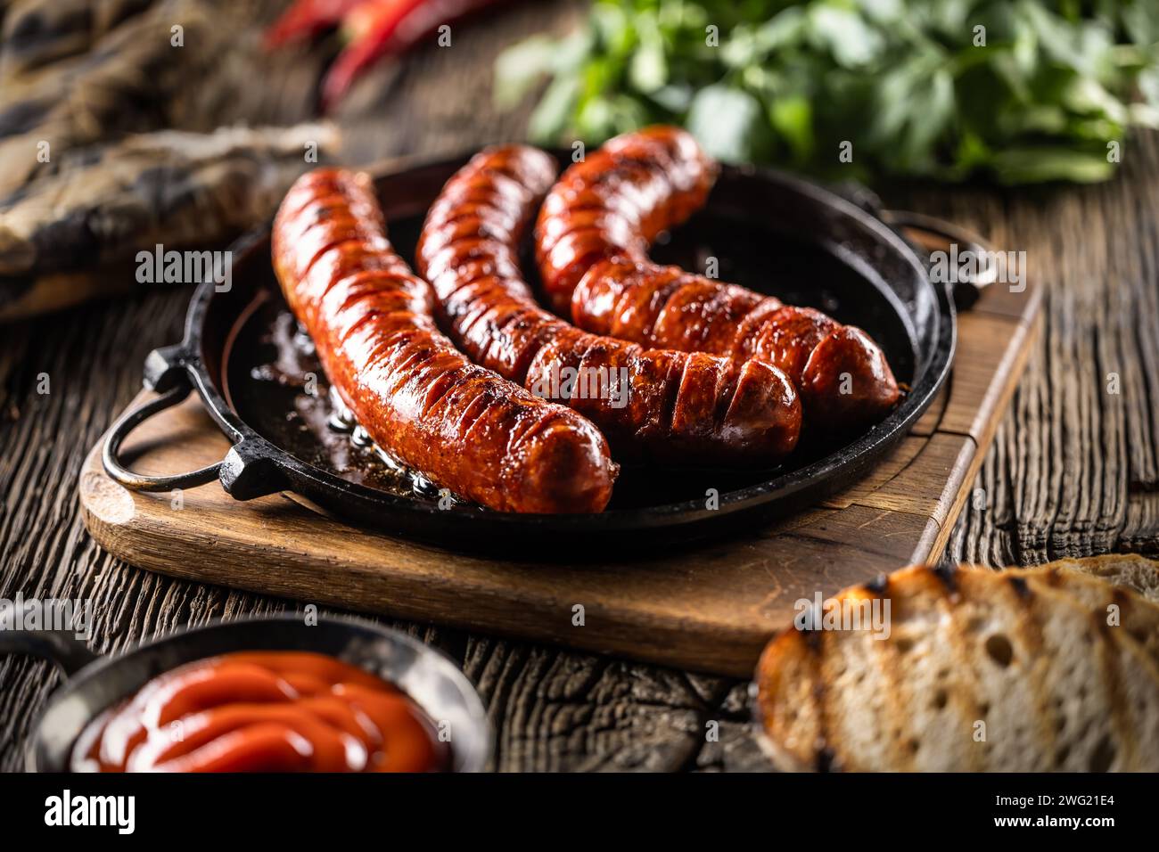 Saucisses frites avec épices sauce barbecue et herbes - gros plan. Banque D'Images