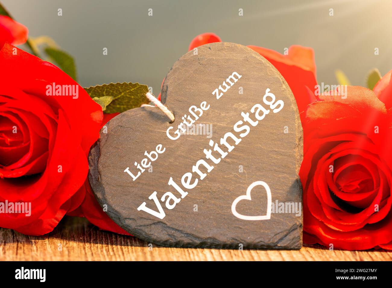 Salutations pour la Saint-Valentin : des roses et un coeur avec l'inscription allemande LIEBE GRÜSSE ZUM VALENTINSTAG (salutations d'amour pour la Saint-Valentin) Banque D'Images