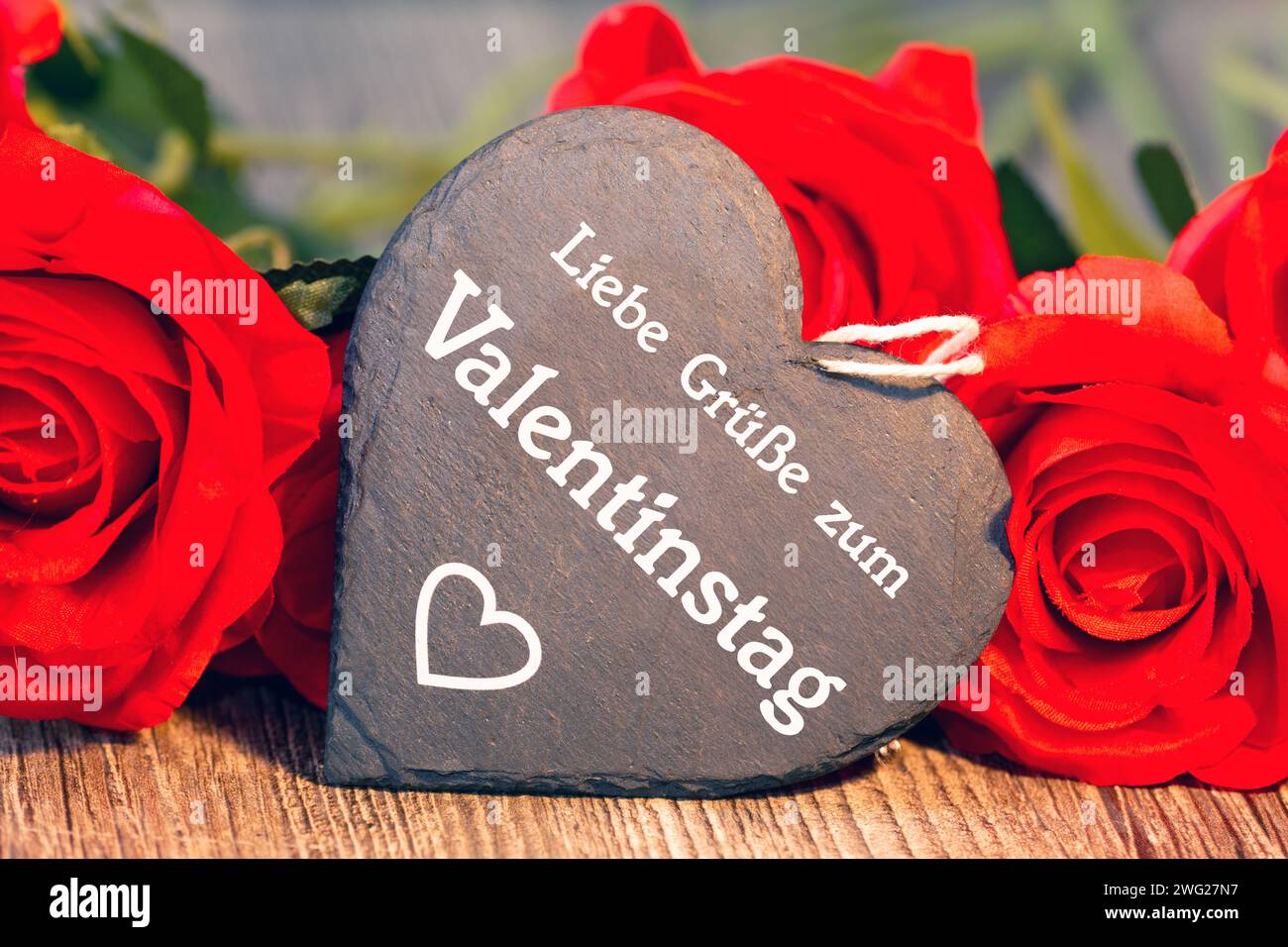 Salutations pour la Saint-Valentin : des roses et un coeur avec l'inscription allemande LIEBE GRÜSSE ZUM VALENTINSTAG (salutations d'amour pour la Saint-Valentin) Banque D'Images