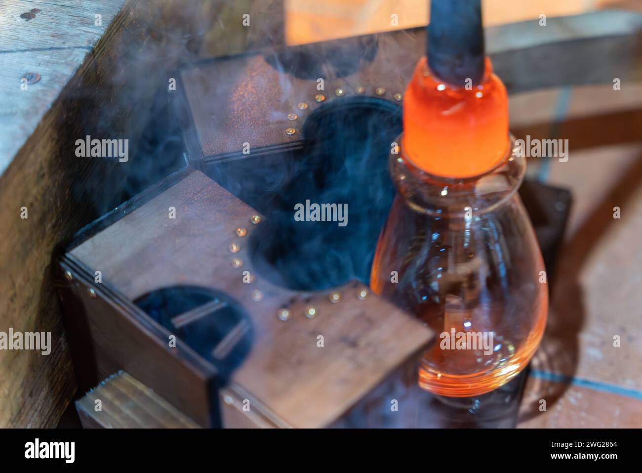 Le processus de fabrication du verre. Souffleur de verre utilisez une forme en bois pour façonner le verre fondu rouge Banque D'Images
