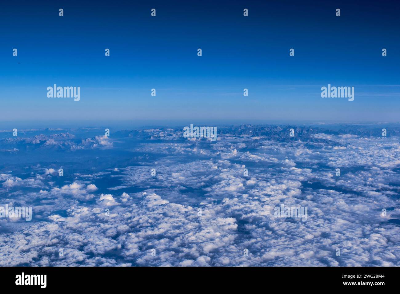 Sommets de montagne vus à travers les nuages depuis l'avion Banque D'Images