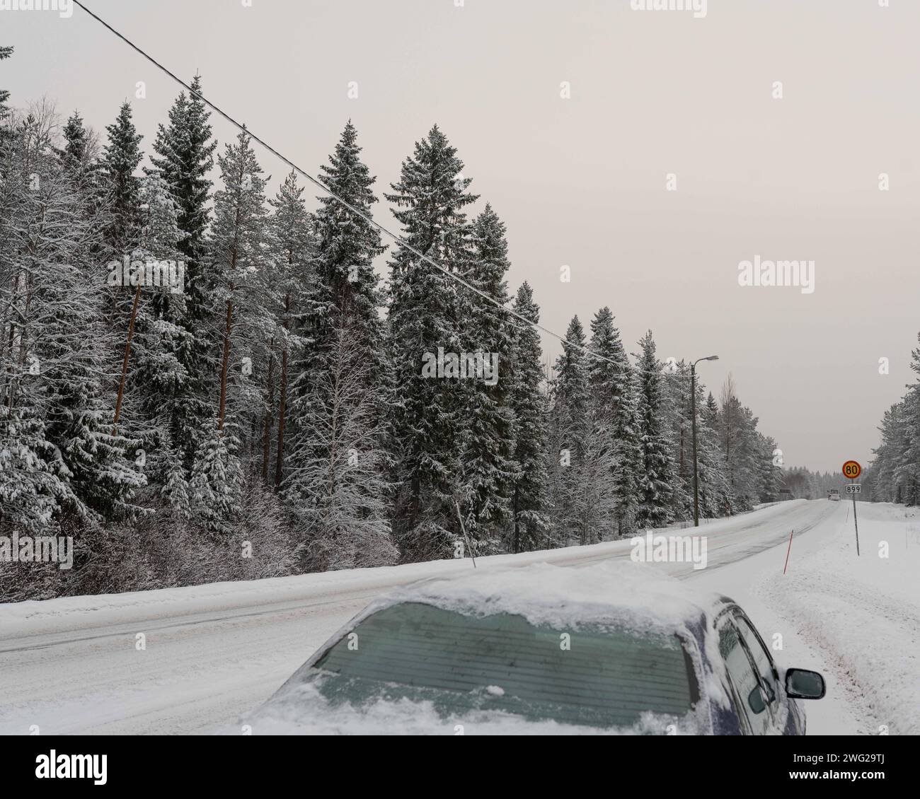 Une route glacée et enneigée à Paltamo, Finlande en hiver. Les conditions routières semblent glacées et dangereuses. Banque D'Images