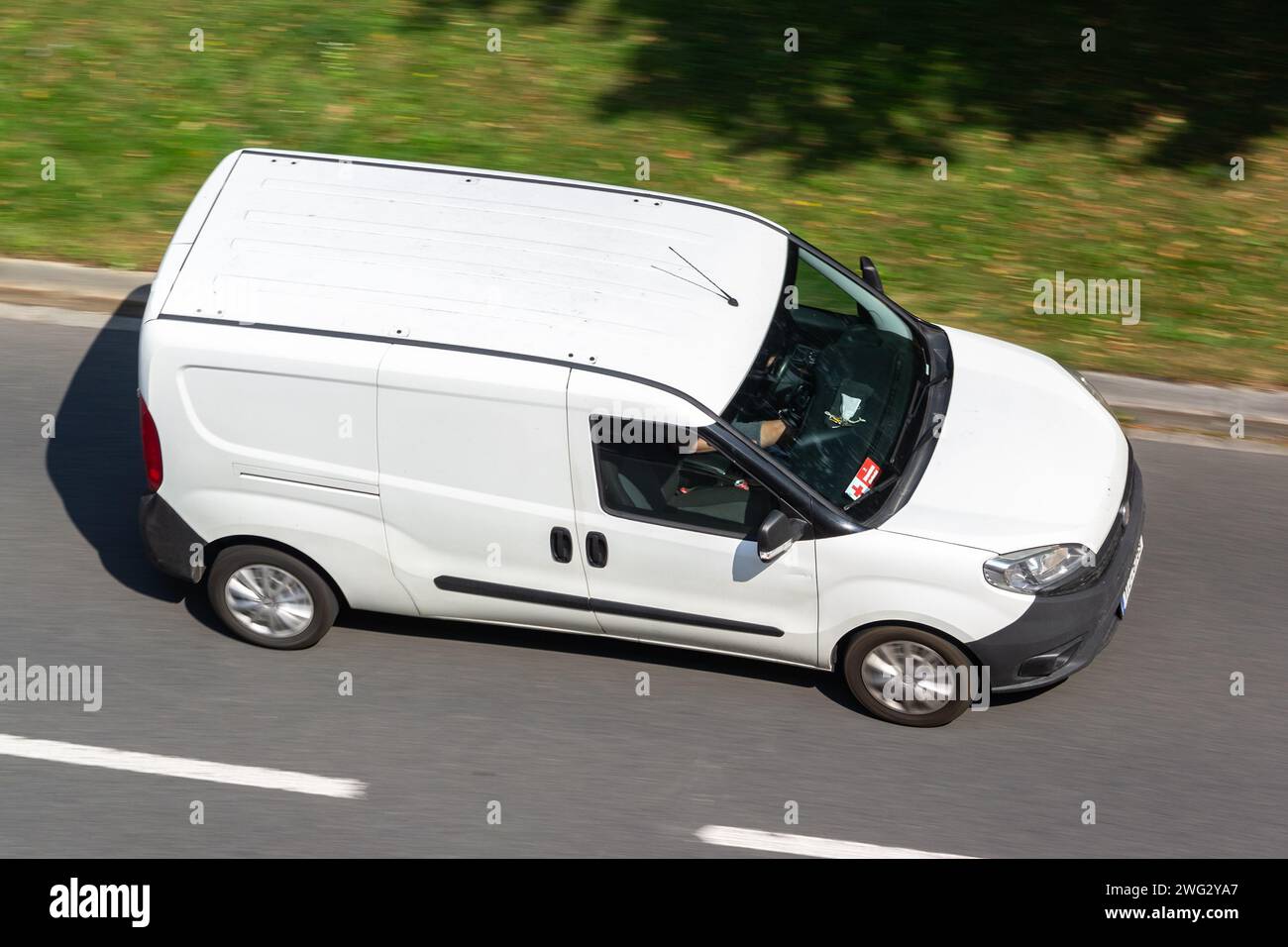 OSTRAVA, RÉPUBLIQUE TCHÈQUE - 23 AOÛT 2023 : Van Fiat Doblo blanc, effet flou de mouvement lors de la livraison de marchandises Banque D'Images