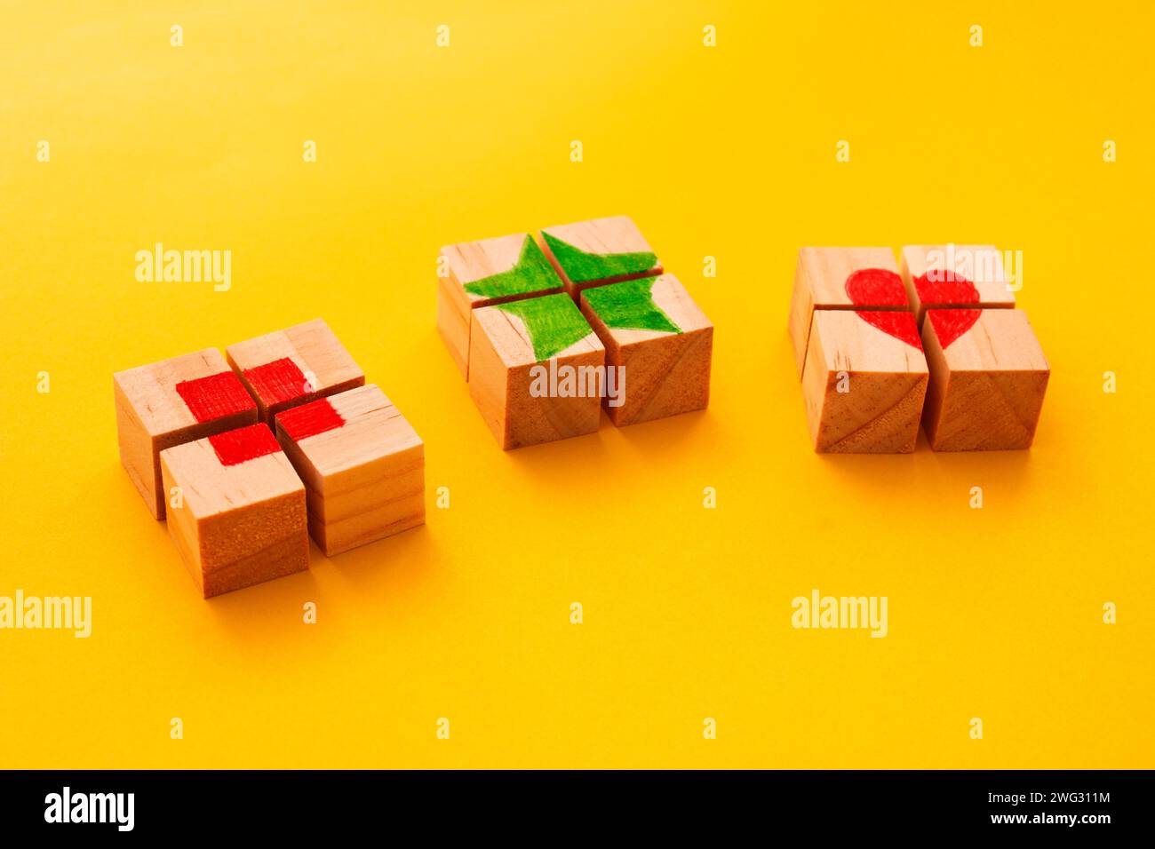 Puzzle de trois cubes en bois formant un carré, une étoile et un coeur en son centre Banque D'Images