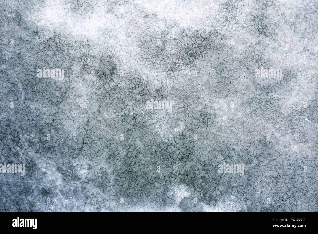 Texture du lac gelé avec beaucoup de fissures sur la surface de la glace. Vue de dessus. Banque D'Images