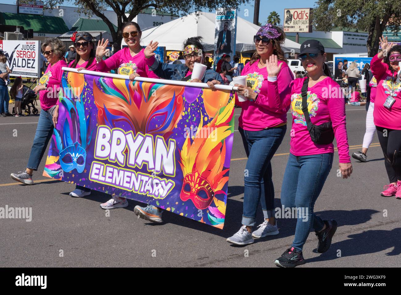 Des femmes en chemises rose vif marchent pour Bryan Elementary dans Parade of Oranges 2024, dans le cadre de la 92e édition annuelle de Texas Citrus Fiesta, Mission, Texas, États-Unis. Banque D'Images