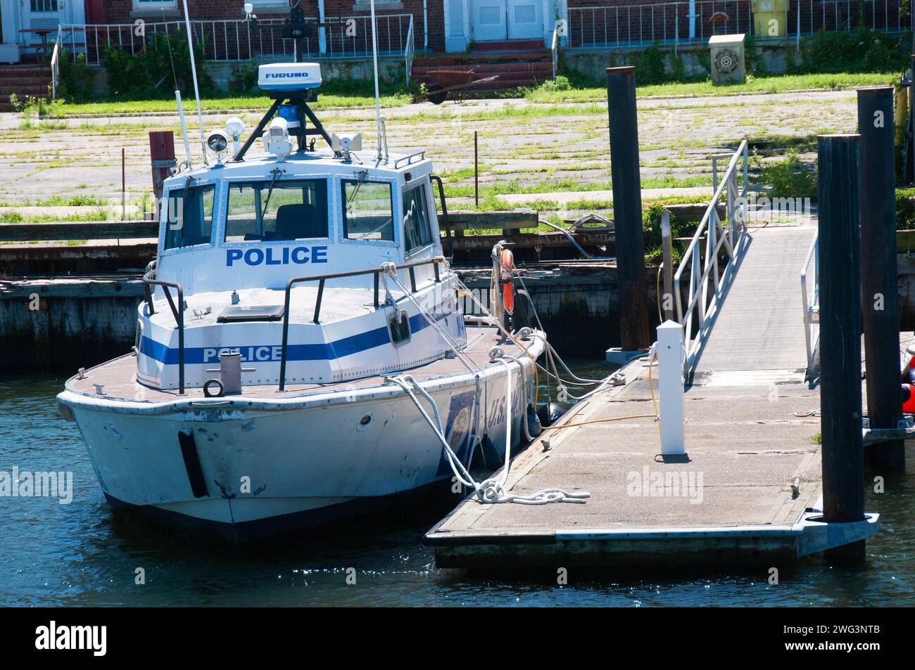 Bateau de la police américaine amarré à un quai clôturé avec une balustrade Banque D'Images