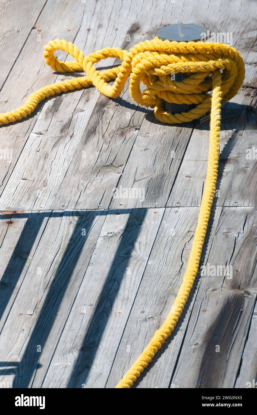 Corde jaune en sisal enroulée sur une borne et tirée dans différentes directions Banque D'Images