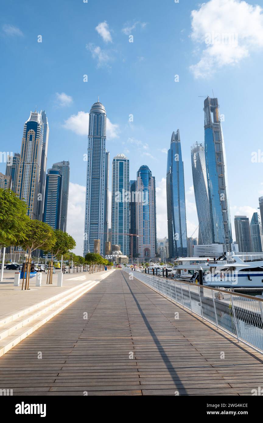 Port de plaisance de Dubaï par une journée ensoleillée dans les Émirats arabes Unis avec une métropole animée rencontre des eaux sereines tandis que les bateaux naviguent sous un horizon majestueux de la ville, encadré par Banque D'Images