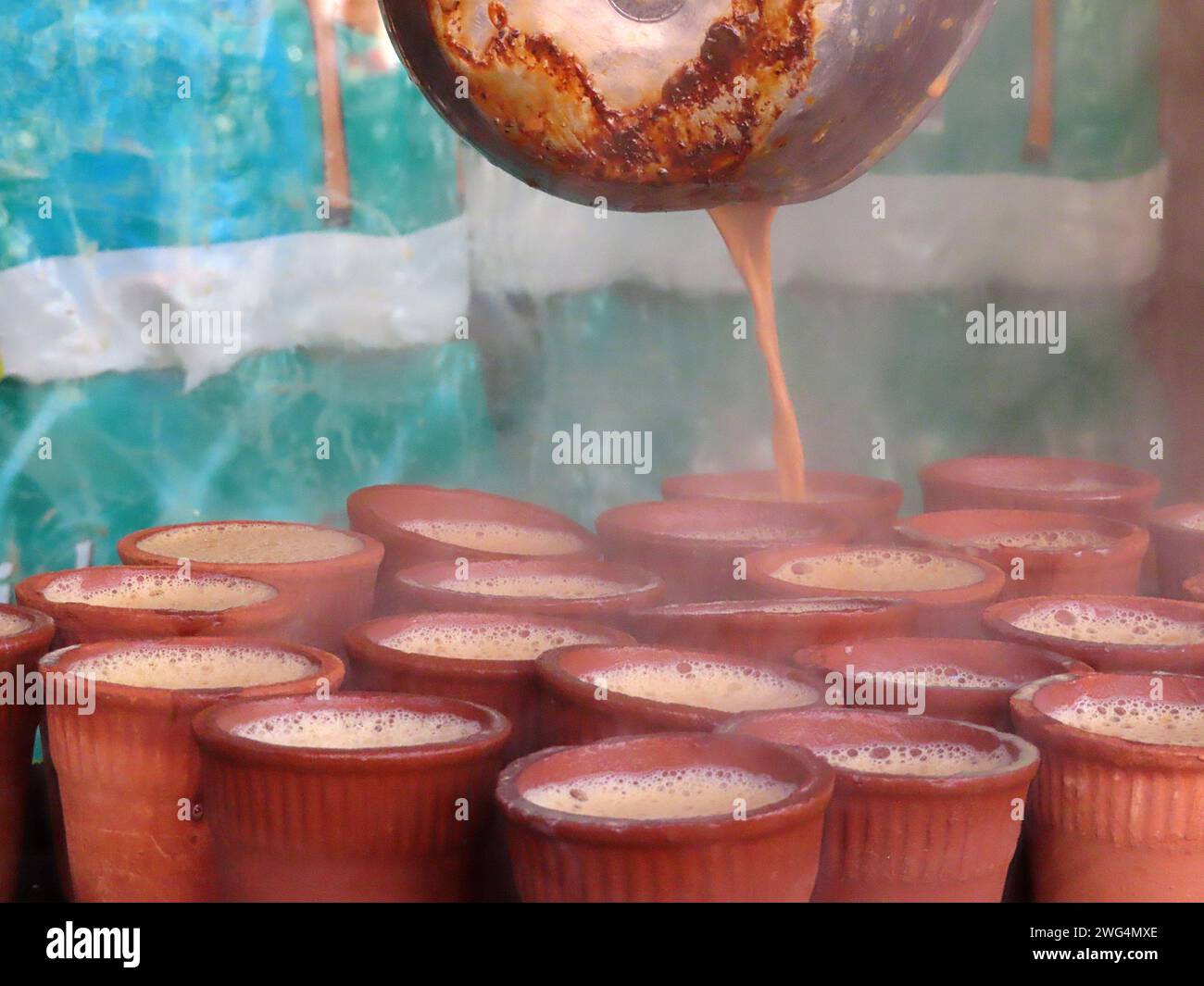 Authentique boisson de rue locale et traditionnelle en Inde et en Asie du Sud Chai masala thé épicé ou non épicé. Liquide versé à partir d'une marmite après avoir été Banque D'Images