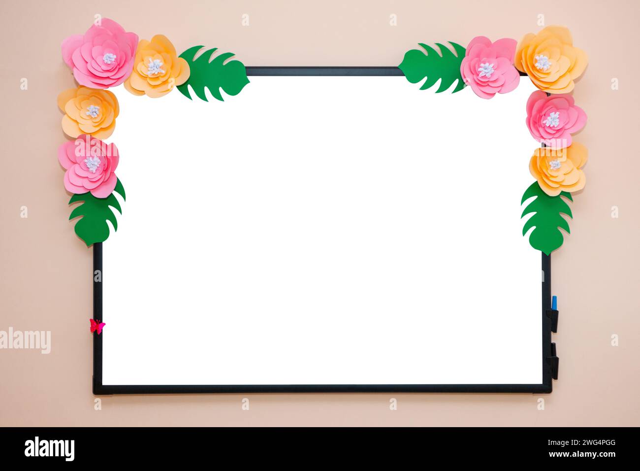Tableau scolaire pour dessiner avec des marqueurs. La planche à dessin est décorée de fleurs artificielles. Banque D'Images