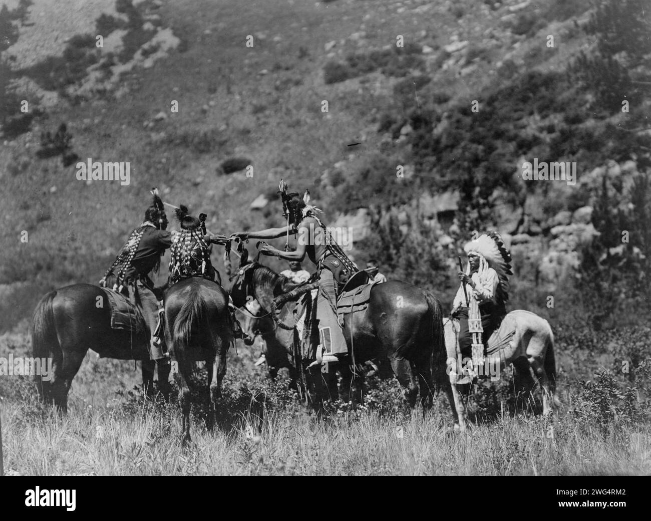 Un échange, c1905. Crow hommes à cheval apparemment impliqués dans un échange. Banque D'Images