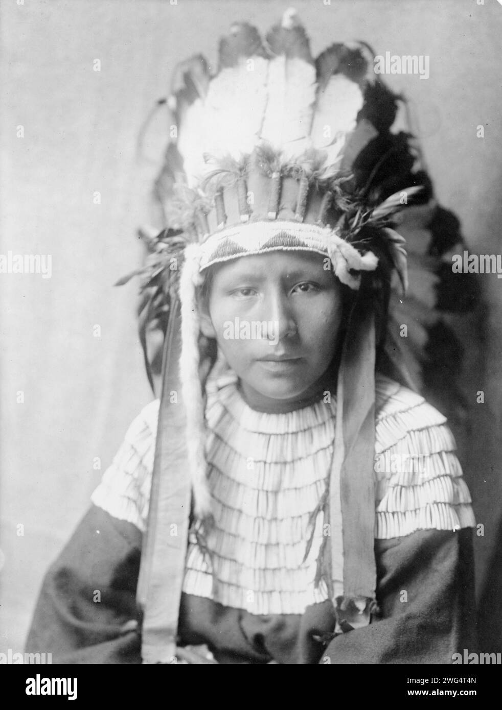 La fille de Bad Horses, c1905. Portrait tête et épaules d'une fille Cheyenne en coiffe de plumes. Banque D'Images