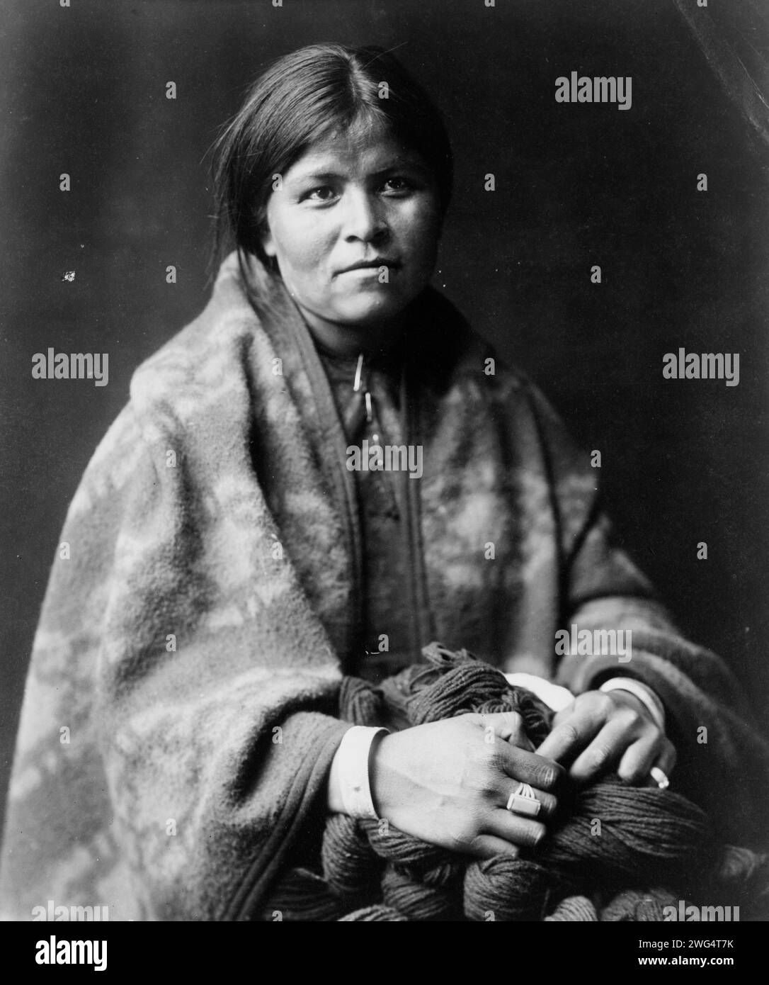 Le fabricant de couvertures - Navaho, c1904. Femme Navajo, portrait en demi-longueur, assise, face à l'avant, tenant le fil, orienté légèrement vers la droite. Banque D'Images