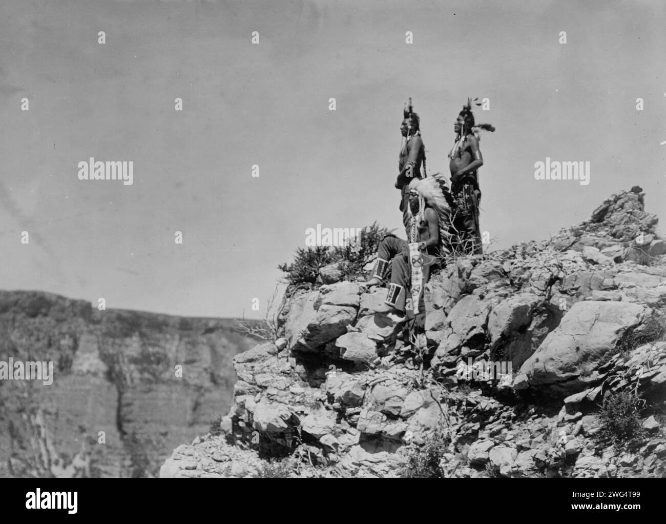 Regarder le signal, c1905. Trois Indiens Crow, un assis, deux debout, face à gauche. Banque D'Images Regarder le signal, c1905. Trois Indiens Crow, un assis, deux debout, face à gauche. Banque D'Images
