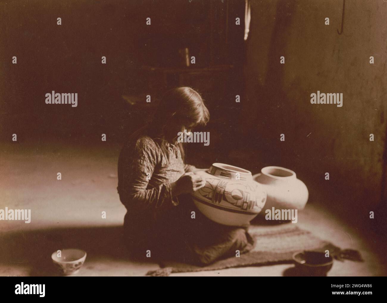 Nunipayo [i.e. Nampeyo] décoration de poteries, c1900. Photographie montrer Tewa Hopi potter Nampeyo assis sur le tapis de peinture dessins sur poterie. Banque D'Images