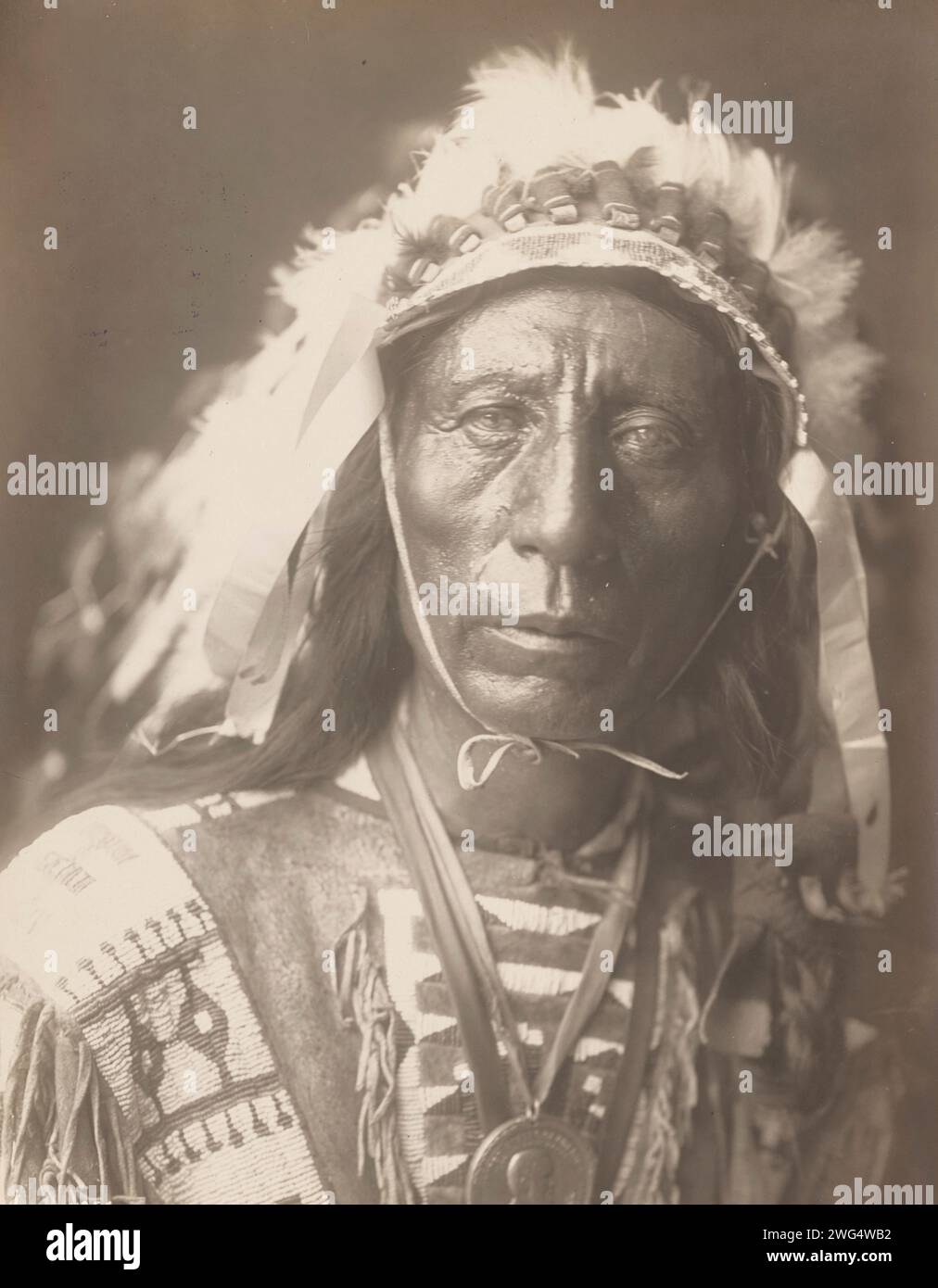 Jack Red Cloud, 1907. La photographie montre le portrait tête et épaules de Jack Red Cloud, debout, portant une coiffe complète, des vêtements traditionnels et un médaillon, face à l'avant. Banque D'Images