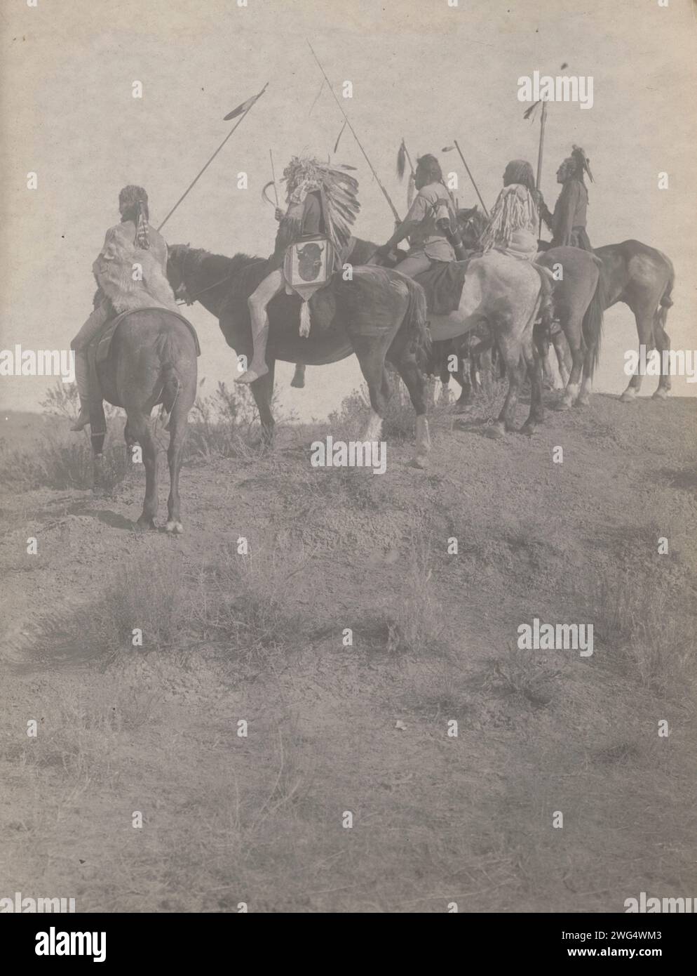 Surplombant la petite corne, 1908. La photographie montre cinq Indiens Crow, Wolf, Fish shows (portant une coiffe), What Way, Lone Tree, et deux sifflets sur le cheval portant des staff. Banque D'Images Surplombant la petite corne, 1908. La photographie montre cinq Indiens Crow, Wolf, Fish shows (portant une coiffe), What Way, Lone Tree, et deux sifflets sur le cheval portant des staff. Banque D'Images