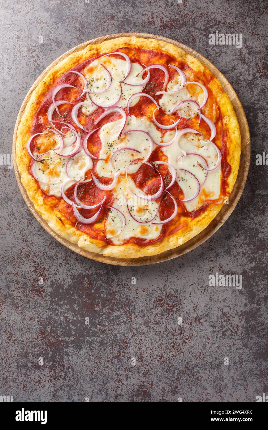 Pizza pugliese est un style de pizza dans la cuisine italienne préparée avec tomate, oignon et mozzarella closeup sur la planche de bois sur la table. T vertical Banque D'Images