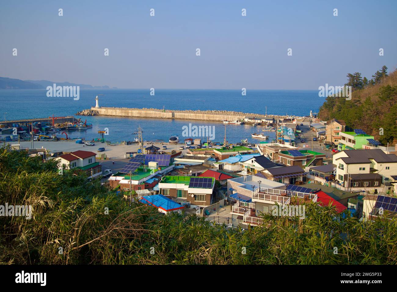 Samcheok City, Corée du Sud - 28 décembre 2023 : une vue panoramique depuis une colline met en valeur les eaux calmes du port de Chogok, des maisons portuaires basses et un brise-lames Banque D'Images