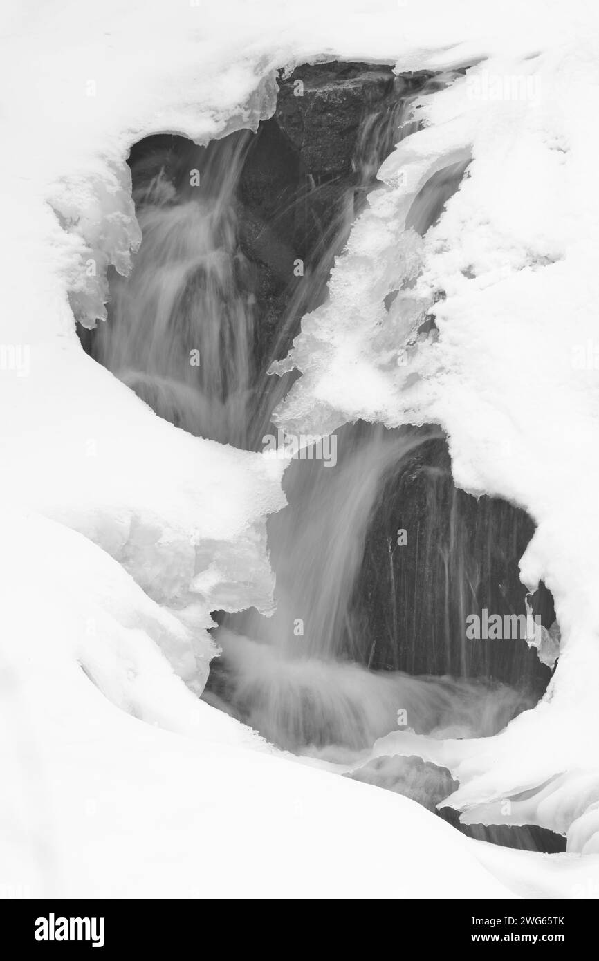 Deux trous dans la glace et la neige révèlent une cascade dans le parc de la Gatineau, au Québec. Banque D'Images