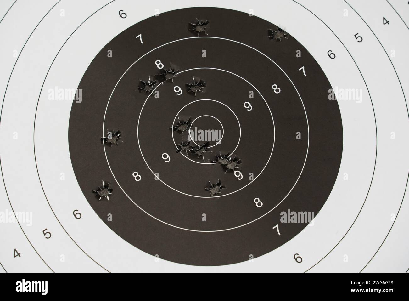 Une cible en papier pour tirer avec des trous de balles de pistolet au centre, photo en gros plan. Photo de haute qualité Banque D'Images