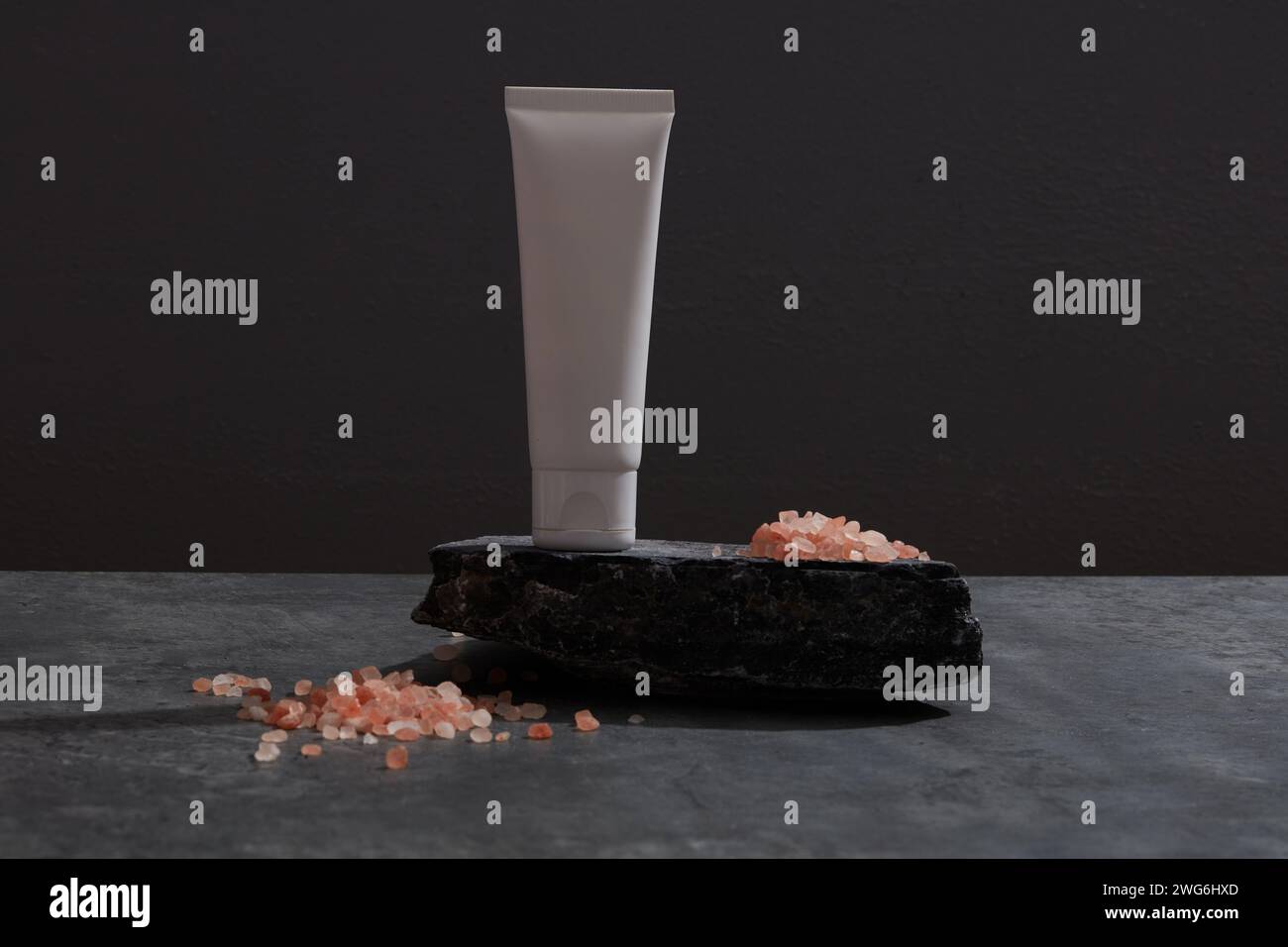 Vue de face de sel rose et cosmétique décoré en fond noir Banque D'Images