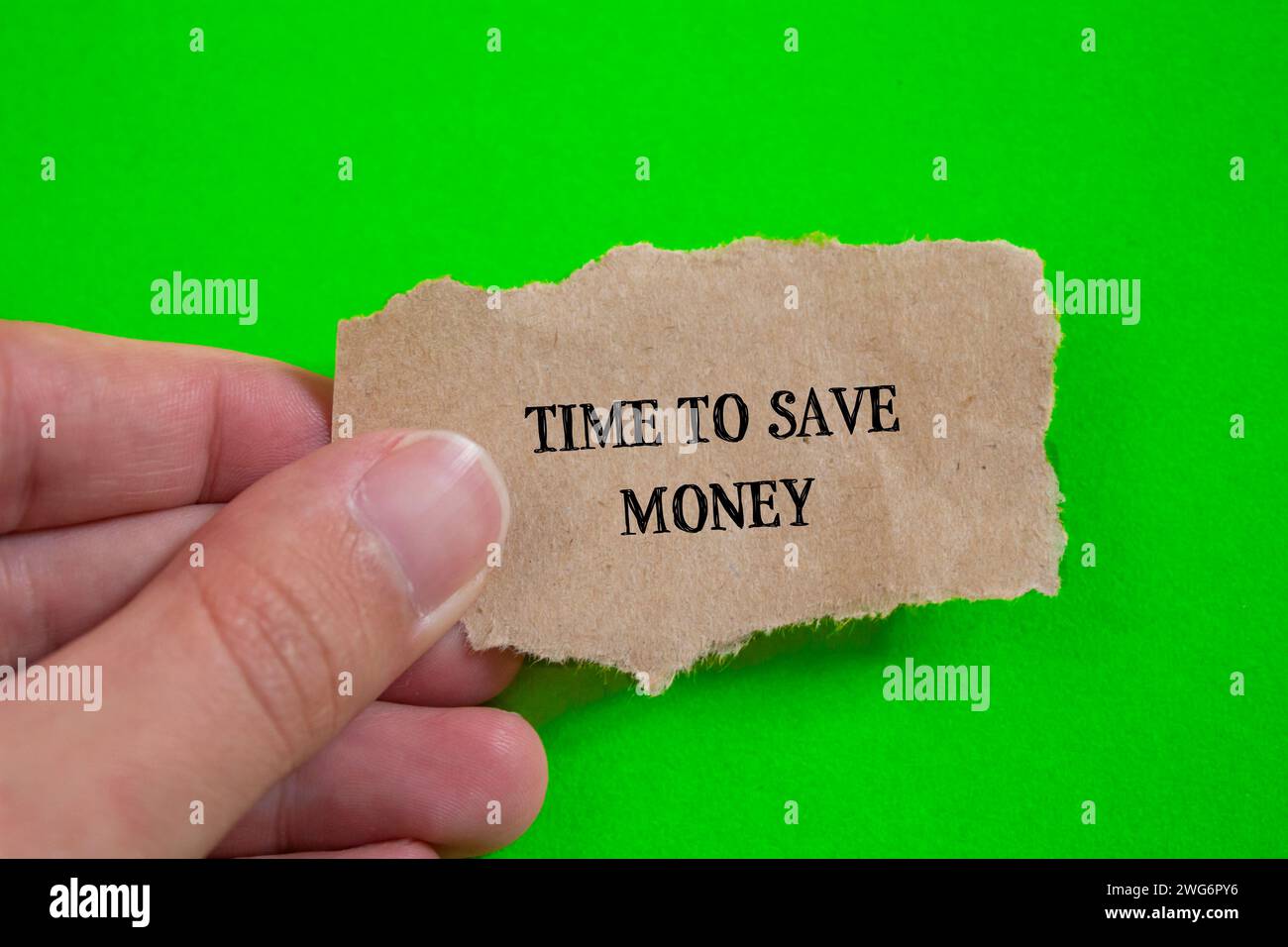 Temps pour économiser de l'argent lettrage sur morceau de papier déchiré avec fond vert. Symbole conceptuel. Vue de dessus, espace de copie. Banque D'Images