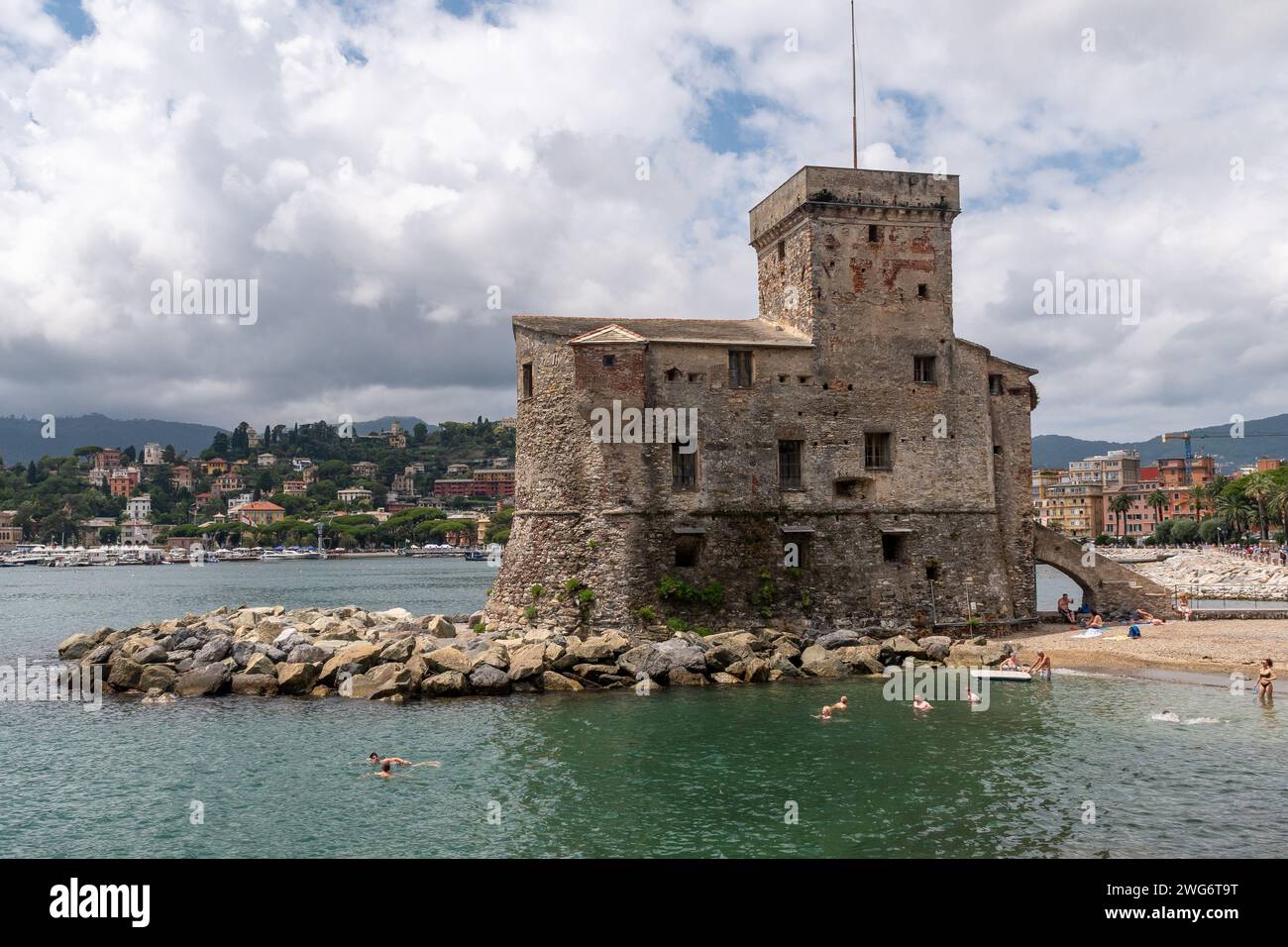 Le château de bord de mer, construit en 1551 pour défendre la ville contre les pirates sarrasins, avec les gens bronzer et nager, Rapallo, Gênes, Ligurie, Italie Banque D'Images