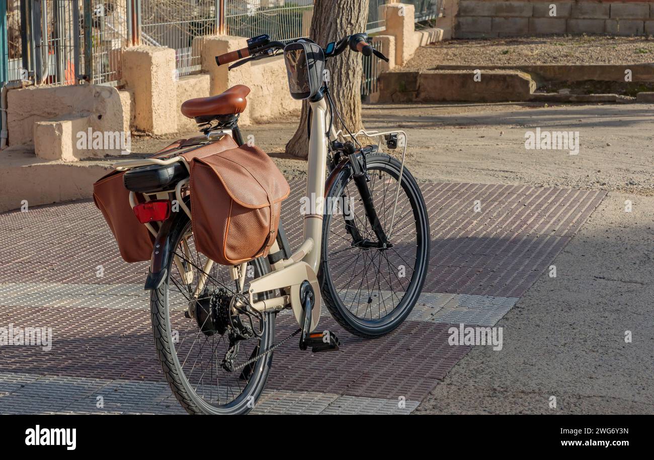 Vélo adulte de couleur crème avec valises et selle en cuir marron Banque D'Images