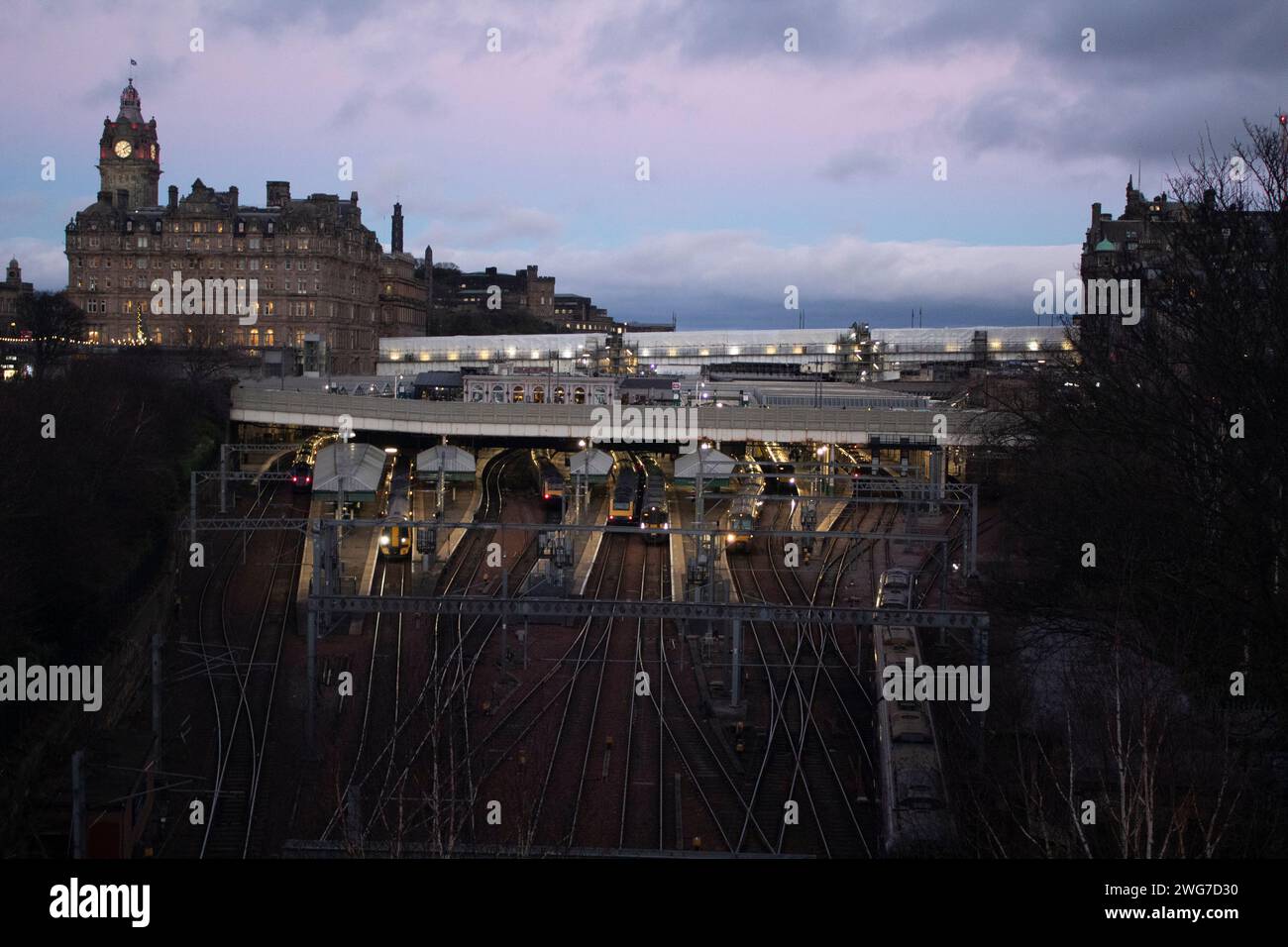 Lignes de train menant à l'entrée et à la sortie de la gare de Waverley au crépuscule d'Édimbourg en Écosse Banque D'Images