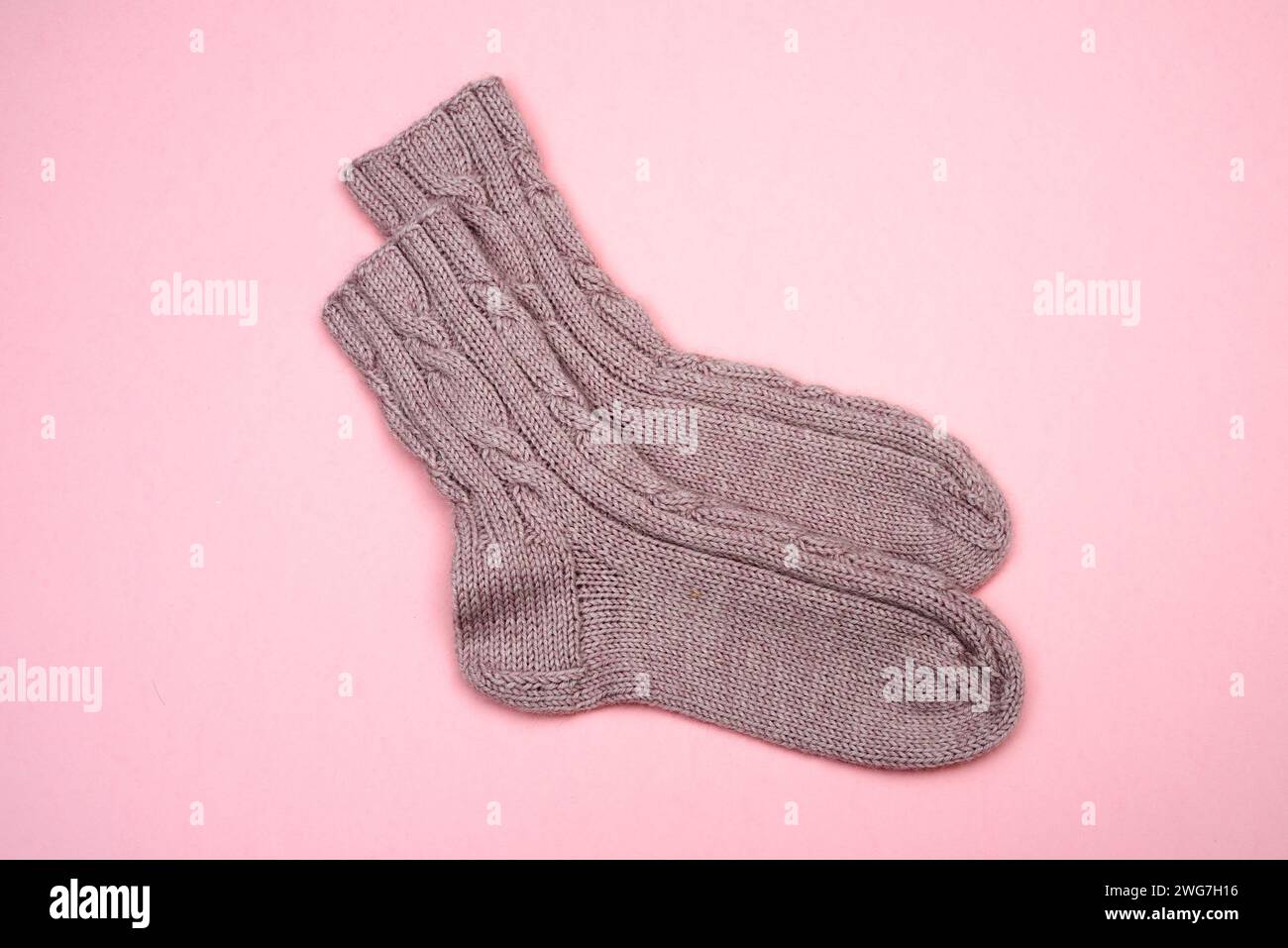 chaussettes en laine tricotée rose sur fond rose Banque D'Images