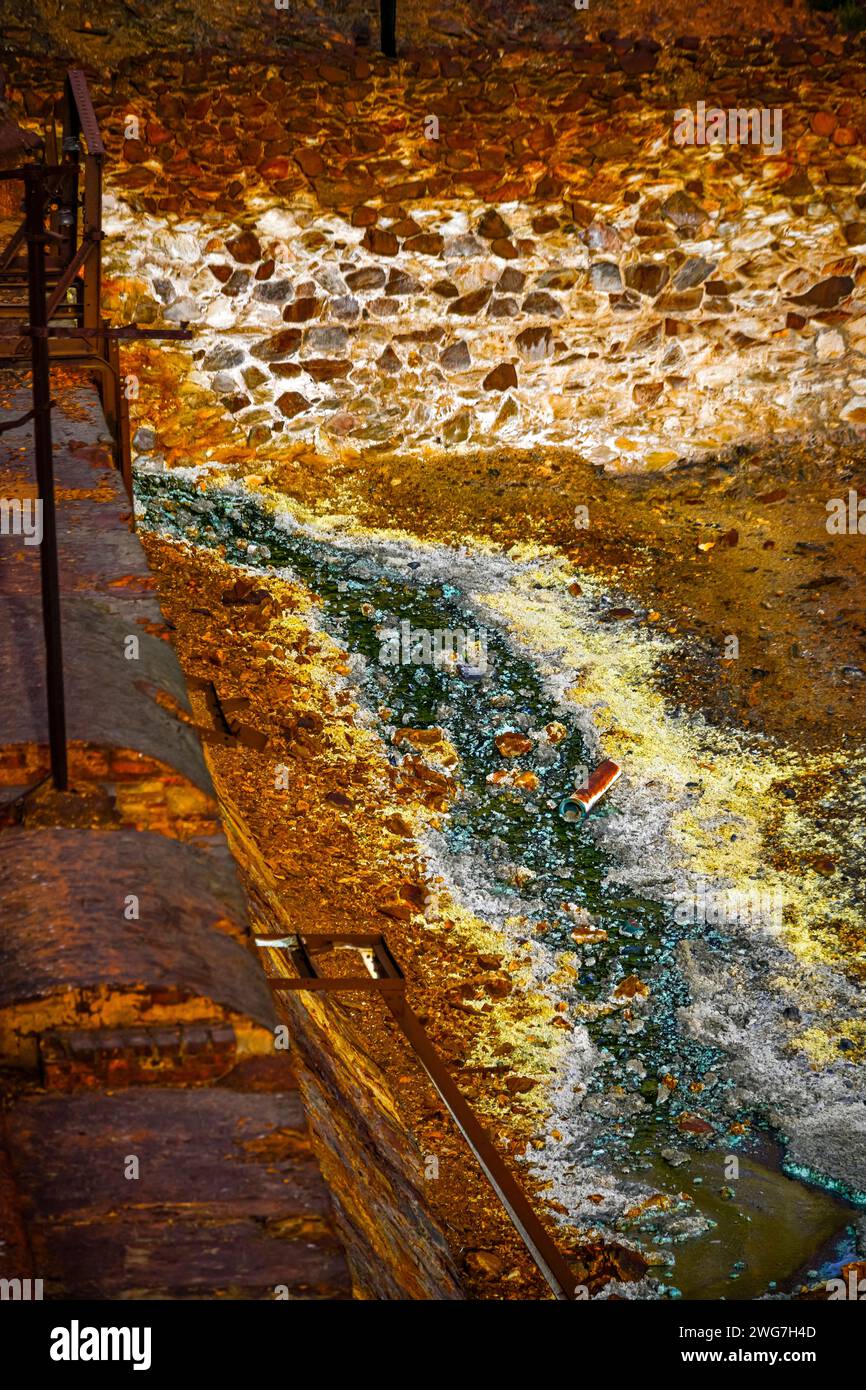 Les teintes orange vibrantes d'un ruisseau acide contrastent avec un mur de pierre dans la zone minière historique de Rio Tinto Banque D'Images