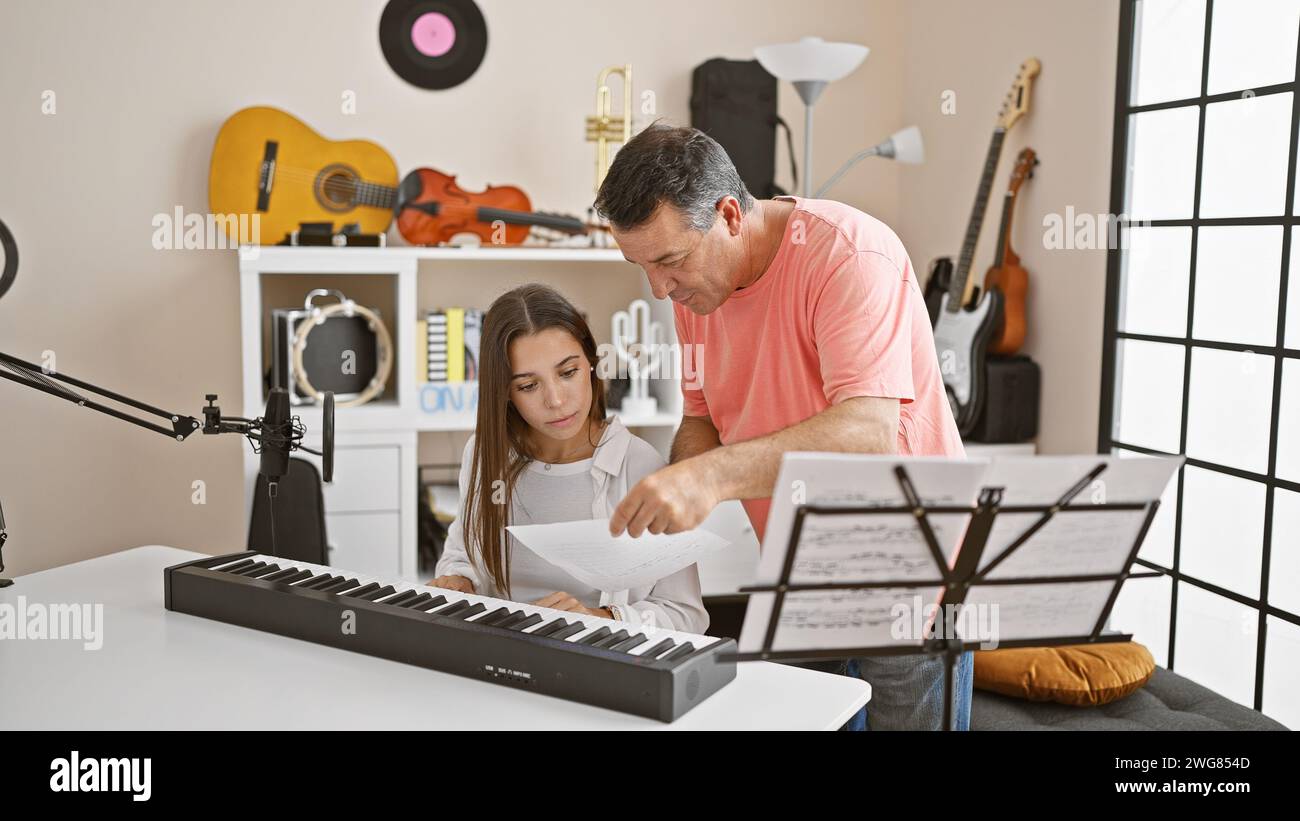 Musiciens hispaniques passionnés, hommes et femmes, ont pris part à une leçon de piano mélodieuse ensemble dans un studio de musique confortable Banque D'Images