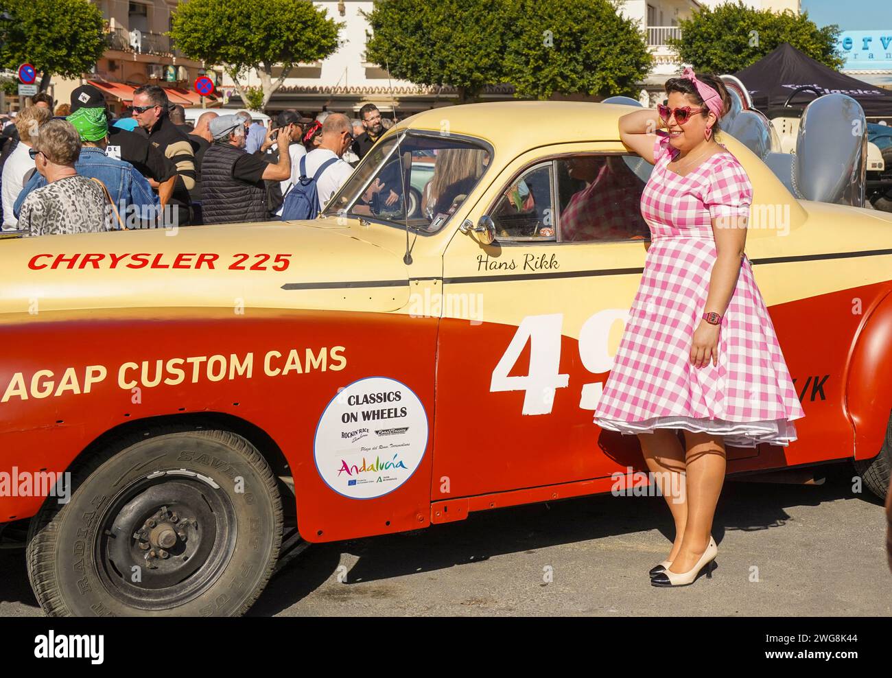 Une femme habillée dans le style des années cinquante posant devant une vieille voiture classique au Rockin Race Jamboree 2024, rockabillies, Torremolinos, Andalousie, Espagne. Banque D'Images