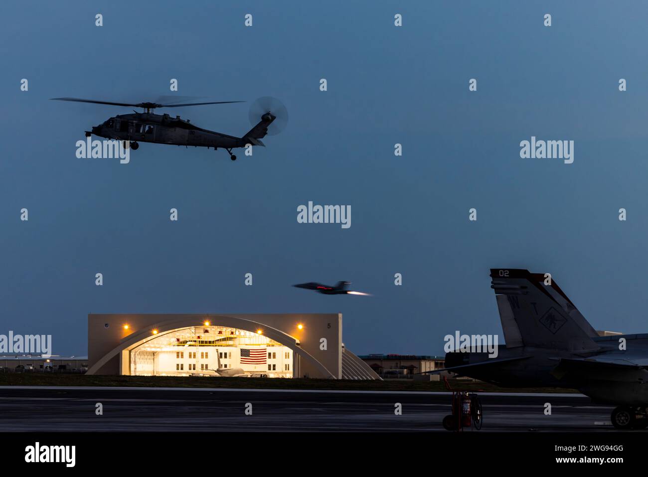Un avion Sikorsky SH-60 Seahawk de la Marine américaine avec l'Escadron de combat en mer 25 de l'hélicoptère de la Marine et un avion F/A-18 Hornet du corps des Marines avec l'escadron d'attaque des Marines (VMFA) 232 opèrent à partir de la base aérienne Andersen, Guam, le 1 février 2024. Surnommé les « Diables rouges », le VMFA-232 a voyagé de la base aérienne du corps des Marines Iwakuni, au Japon, à Guam dans le cadre du déploiement de leur programme de relocalisation de l’entraînement aérien pour s’entraîner multilatéralement avec les alliés et les partenaires, et améliorer la préparation au combat de l’escadron. (Photo du corps des Marines des États-Unis par le sergent Jose Angeles) Banque D'Images