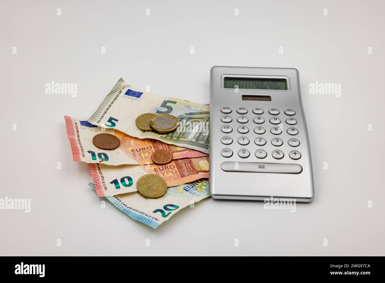 Dans une crise avec une inflation élevée et des prix en hausse, vous tournez chaque centime deux fois et calculez les coûts et le salaire avec une calculatrice Banque D'Images