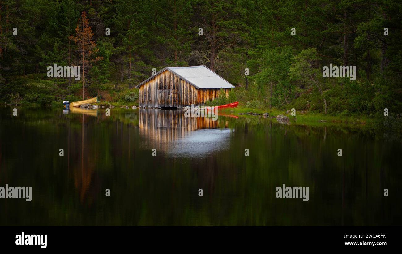 Bateaux couchés sur le rivage à côté d'un hangar à bateaux sur un lac, paysage, format paysage, réflexion de l'eau, atmosphérique, Tynset, Innlandet, Norvège Banque D'Images