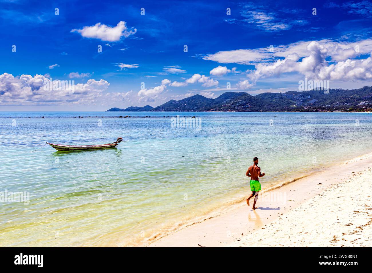Jogging et bateau de pêche, plage de Chaweng, Ko Samui, Thaïlande Banque D'Images