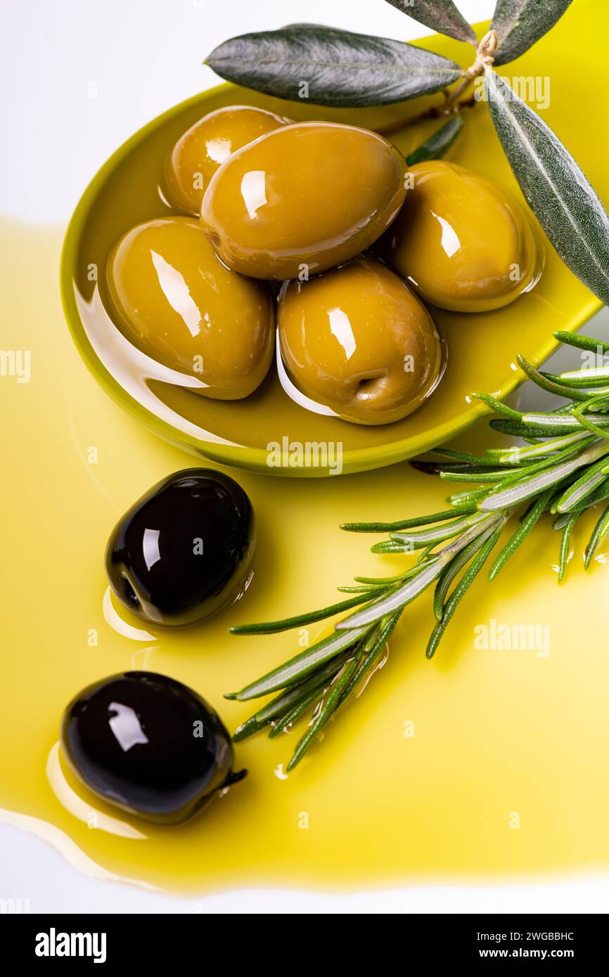 au premier plan, dans une louche verte, il y a des olives à l'huile d'olive extra vierge aromatisée au romarin Banque D'Images