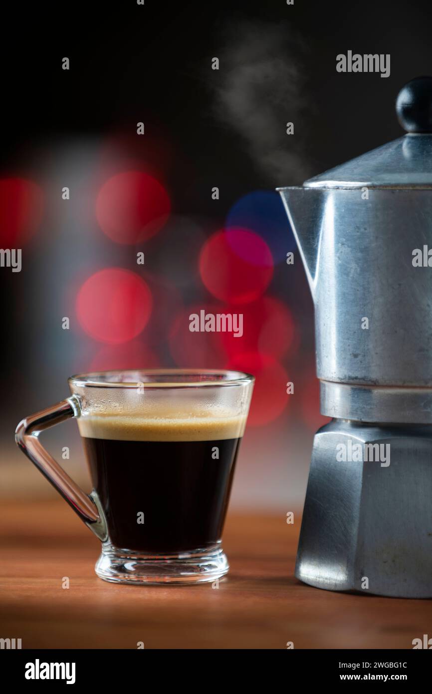 Au premier plan un vieux moka italien et une tasse de café chaud. en arrière-plan un effet bokeh agréable Banque D'Images