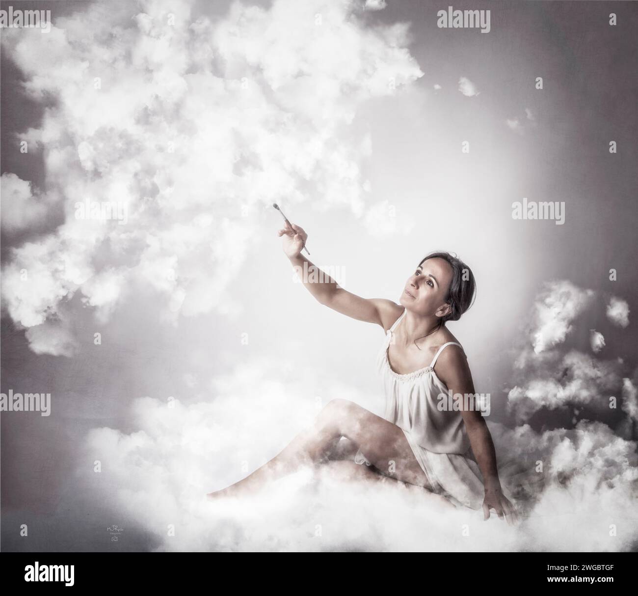 Portrait d'une femme assise sur un nuage moelleux tout en peignant des nuages Banque D'Images